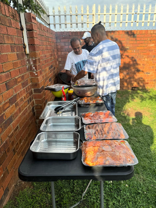 Many hands helping to braai the meat